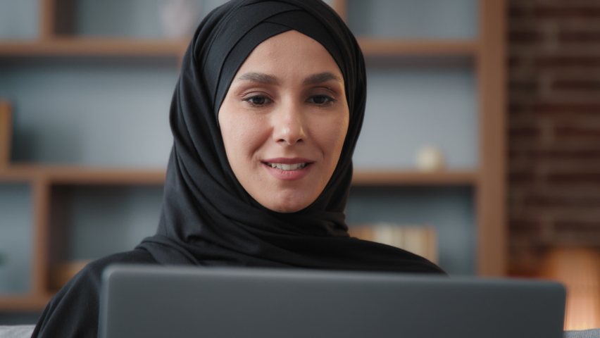 Close up Muslim Arabian Islamic woman in hijab looking at laptop screen computer monitor e-commerce buying online in internet service store typing chatting in social networks working remote browsing Royalty-Free Stock Footage #1094288385
