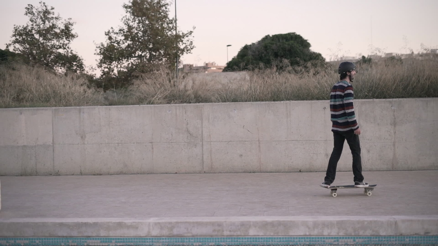 Follow shot of young man riding skateboard in the city 