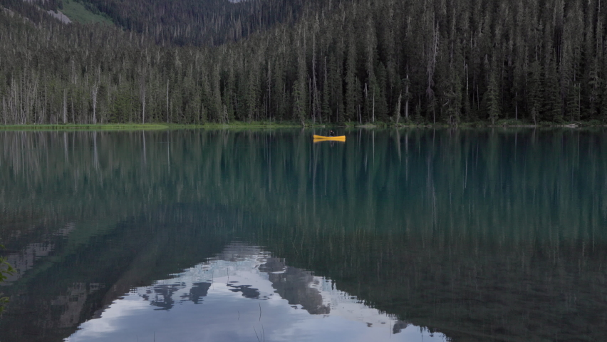 Canadian forest mountain lake, emerald lake, evergreen forest, canoe, outdoors, wilderness scene, camping. 4K PRORES 24FPS