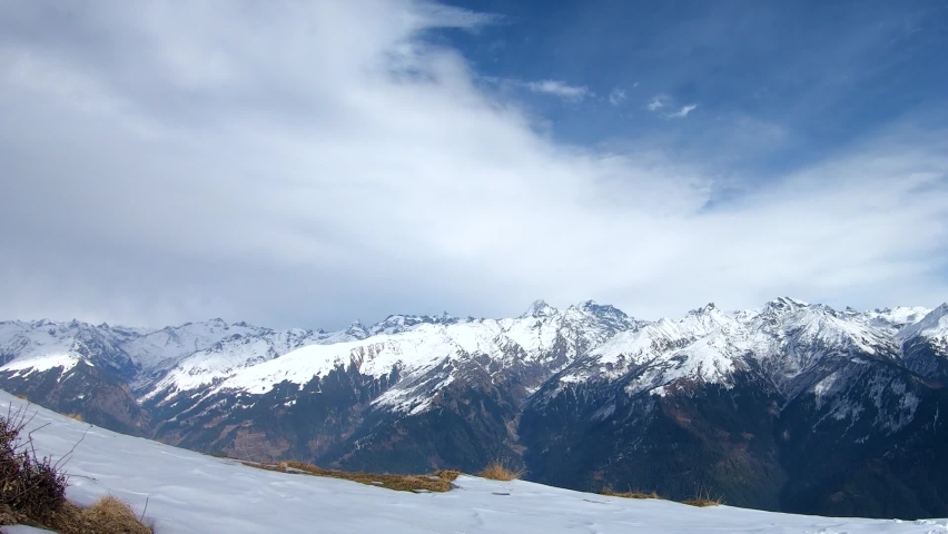 Time lapse of clouds above the snow covered peaks of the Himalayan mountain range during the winter season as seen from top of mountain at Manali in Himachal Pradesh, India. Timelapse of Himalayas. | Shutterstock HD Video #1094294175