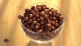 A healthy breakfast poured in glass along sunrise. Chocolate cereals falling in a bowl. Making cereals chocolate breakfast tasty healthy. Cereals and cereal products flakes pour in a bowl. - Powered by Shutterstock - Get 15% off with code: PIKWIZARD15