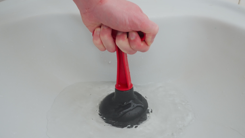 using plunger sink to cleaning drain hole blockage. clogged pipes cleaning with rubber pipe plunger. plumbing tools to unclog clogged sewage. sewer pipe blockage problem solution. clogged drain pipe Royalty-Free Stock Footage #1094309071