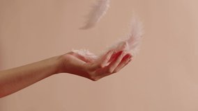 White feathers texture, hand catching soft plumelets on pink background close-up. Softness and fur concept.  - Powered by Shutterstock - Get 15% off with code: PIKWIZARD15