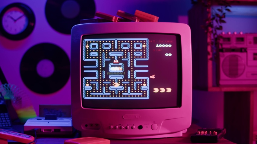 BARCELONA, SPAIN, 22 JUNE, 2022: Playing old game, Pac-Man, using retro playstation on television. Vintage tv and cartridges. Antique video gaming, nostalgia. 