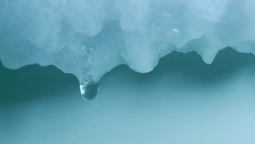 Ungraded: Melting ice. Drops of water dripping from a melting frozen piece of ice and snow due to warming or defrosting. Ungraded H.264 from camera without re-encoding. - Powered by Shutterstock - Get 15% off with code: PIKWIZARD15