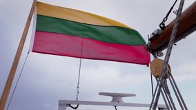 Lithuanian flag fluttering in the wind on an old sailboat. Slow notion video.