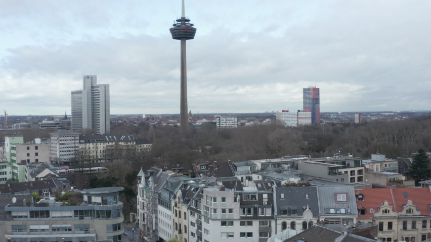Residential neighbourhood and park with leafless trees. Cologne telecommunications tower exceeding surrounding development. Cologne, Germany