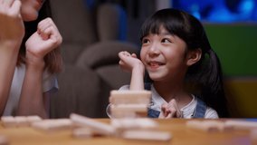 Cheerful girl playing wooden game with concentration, Little daughter enjoying to play game with mother at home, Young mother having activities with kid, Activities with child development