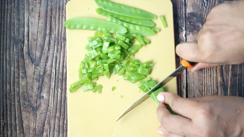 women cutting Holland beans on the cutting board