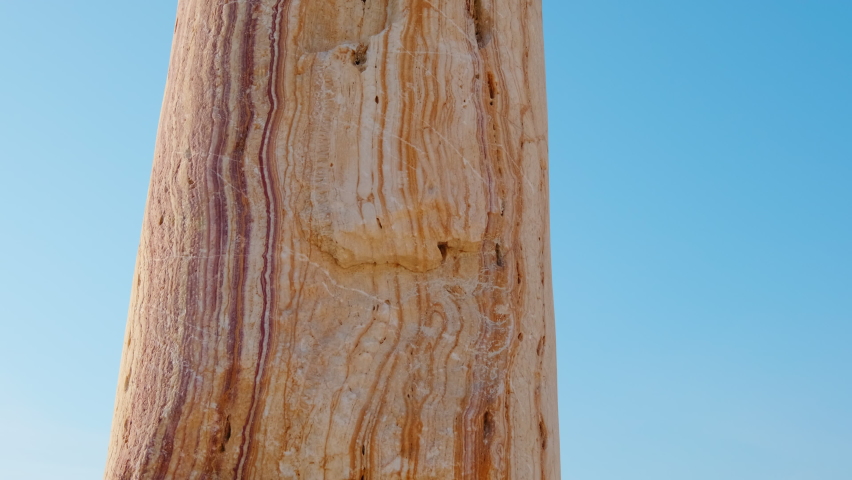A man touches an ancient pillar
