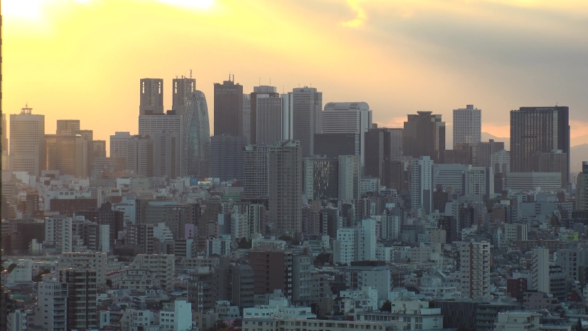 TOKYO, JAPAN : Aerial high angle sunset CITYSCAPE of TOKYO. View of office buildings at downtown area around Shinjuku. Long time lapse shot, dusk to night. Japanese urban metropolis concept video.