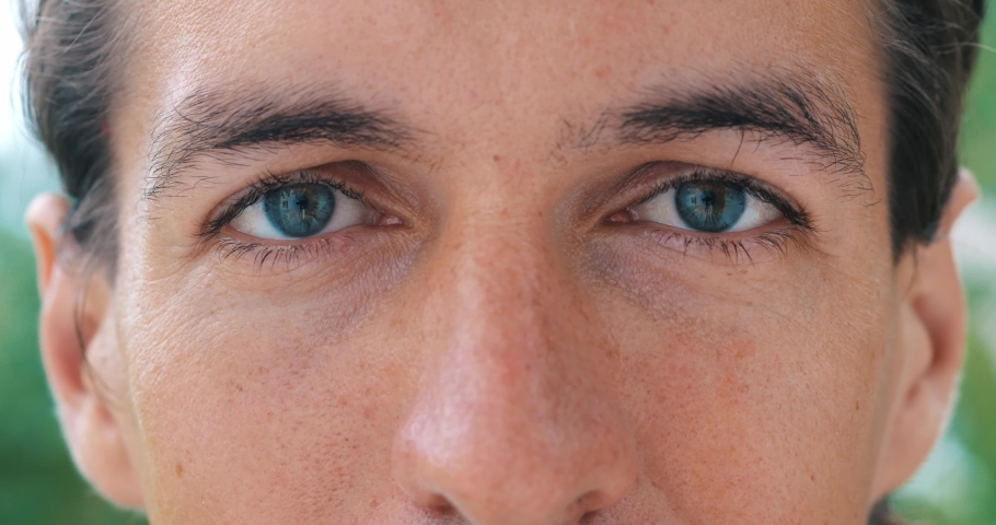 Close-up face portrait of a handsome blue eyed man with Caucasian appearance looking calm, smiling, posing with beautiful insightful look at the camera. Cropped view. Headshot.
