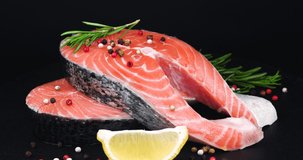 Trout Steaks Rotation Video. Raw Slices with Perfect Texture of Uncooked Red Fish. Sea Food. Freshwater Fish. Healthy Eating Concept with Lemon, Rosemary and Pepper