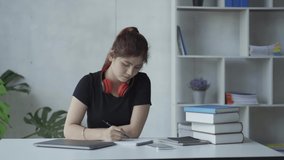 Asian woman wearing headphones with laptop and book in online education concept grid