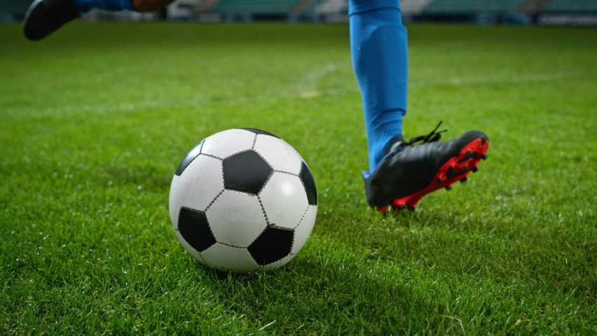 Close-up of a Leg in a Boot Kicking Football Ball. Professional Soccer Player Hits Ball with Fierce Power, Scores Goal, Grass Flying. Super Slow Motion Cinematic Low Angle Ground Artistic Shot Royalty-Free Stock Footage #1094344341