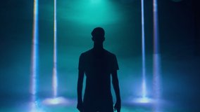 Male dancer performing in the night club. Contemporary, hip-hop, house dance. Silhouette of a dancer in a blue neon light lamps on a black background. High quality 4k footage - Powered by Shutterstock - Get 15% off with code: PIKWIZARD15