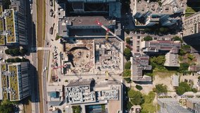 Contruction site surrounded by modern housing estate with greenery in the center of Warsaw Poland. Top-down horizontal drone shot. High quality 4k footage