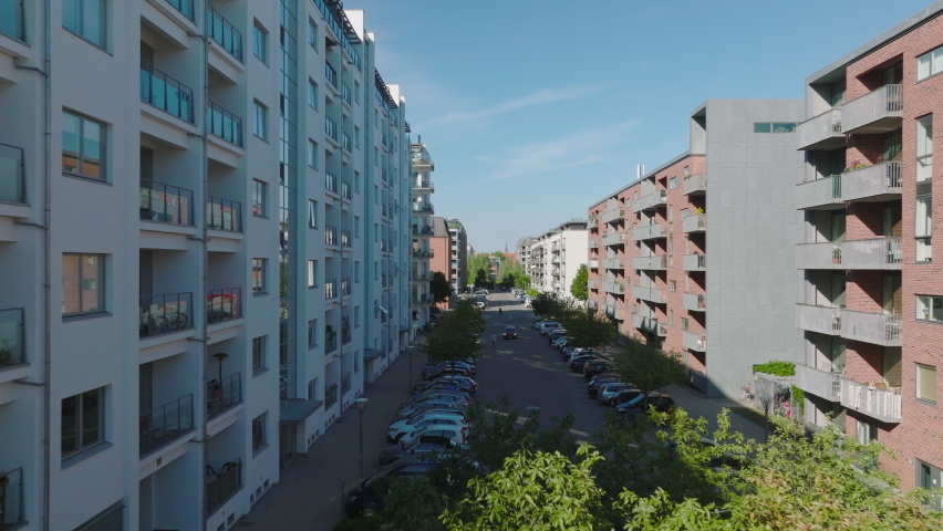 Modern multistorey apartment buildings in housing estate. Forwards ascending fly above street. Copenhagen, Denmark