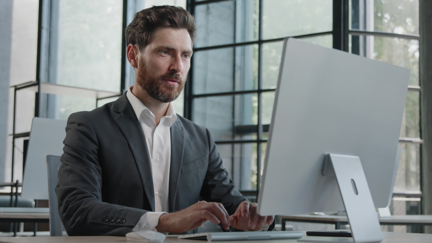 Adult Caucasian bearded businessman in office space working with online computer app website, showing with index finger pointing with forefinger to screen wave head yes choice recommendation advertise Royalty-Free Stock Footage #1094372019