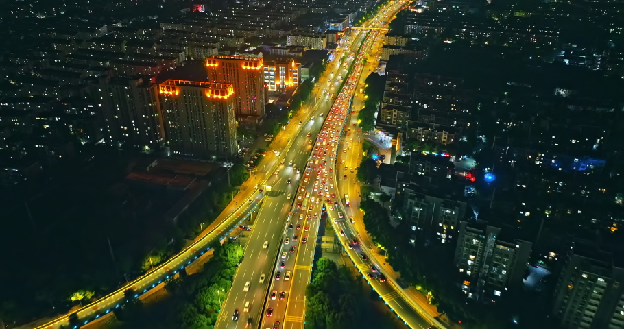 Aerial footage of busy city road and skyline at night in Suzhou, China.
