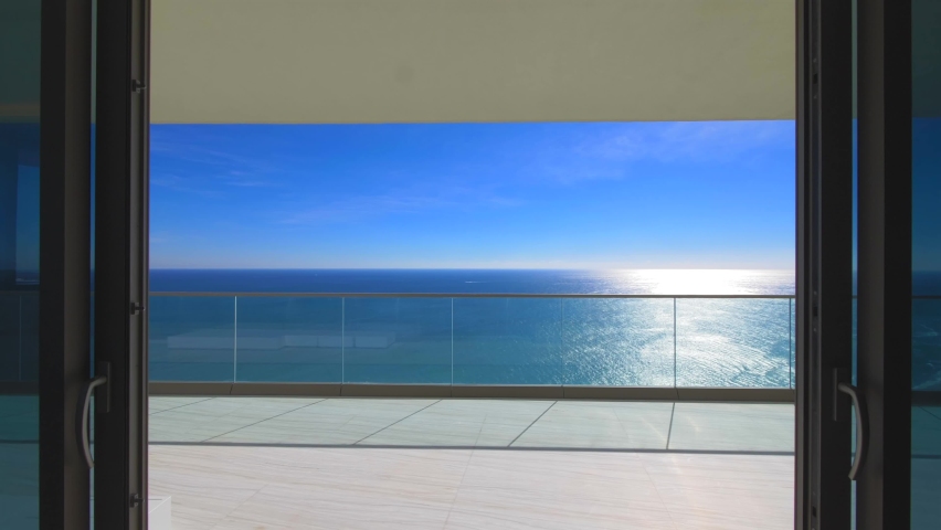 Exit to the terrace overlooking the ocean. View of the ocean and clear sky. Luxury living. Royalty-Free Stock Footage #1094376663