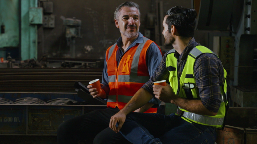 the worker is resting and conversing with his colleague in the factory