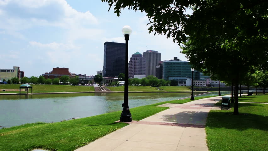 The camera pans left facing downtown Dayton, Ohio, panning across to show a swing and the Riverscape fountains.