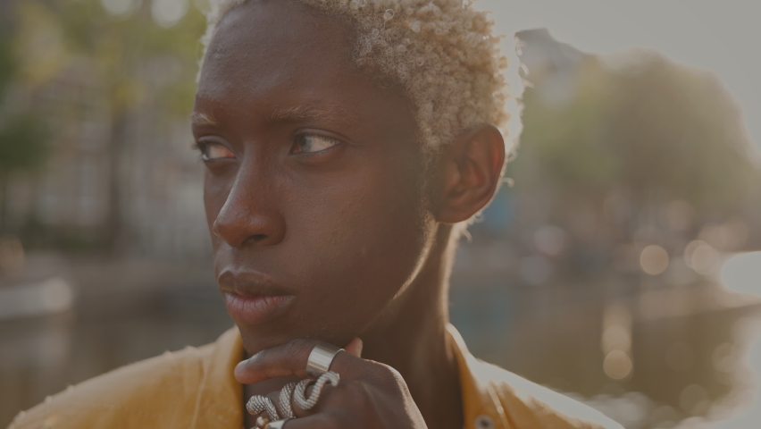 Portrait Of Young Boy With White Dyed Hair. Behind Him Is Canal With Boats And Wonderful View Of City.