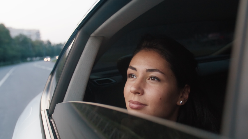 A young beautiful woman rides in a taxi, looks out the open window, enjoys the road. Road, trip, car. Slow motion 4k footage Royalty-Free Stock Footage #1094384593