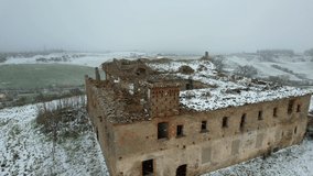 Aerial video of an abandoned convent in a state of disrepair. It is snowing outside. Called the Convento dei Frati Cappuccini, and dates from the 16th century. Located in Grottole, southern Italy.