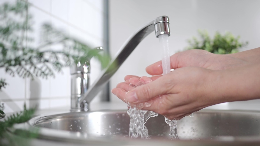 A stream of clean water drink flows into human hands. Wash hands and hygiene. Water consumption, environment, water pollution and water scarcity concept | Shutterstock HD Video #1094398813