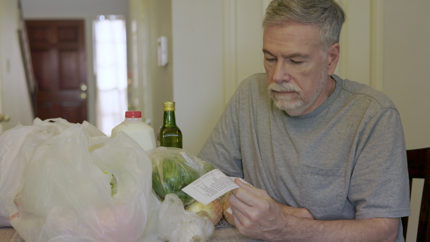 A senior adult Caucasian male concerned about the high cost of groceries due to inflation. | Shutterstock HD Video #1094398891
