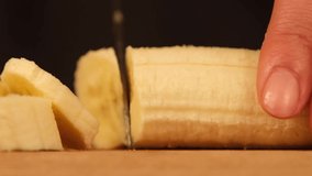 Chopping a banana on a black background for a b roll video