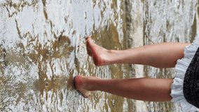 young hispanic south american woman relaxing at the river with feet on the water