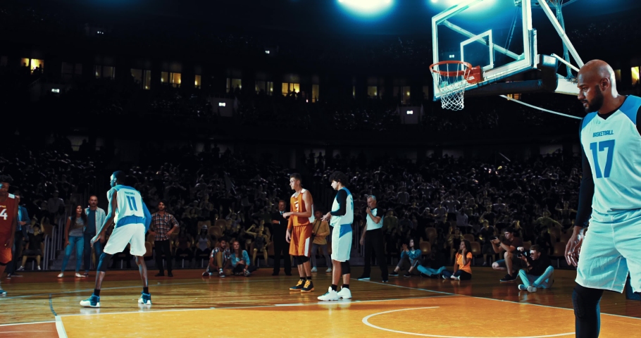 Basketball player throwing the ball into the hoop from a distance and scoring points. Opposite team player blocking. Players celebrating. 3d made basketball stadium with animated crowd. | Shutterstock HD Video #1094416373