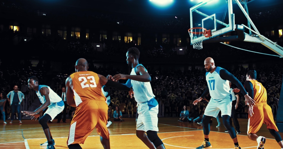 Basketball player throwing the ball into the hoop in a jump and scoring points. He is hanging on the rim. Opposite team player blocking. 3d made basketball stadium with animated crowd. | Shutterstock HD Video #1094416375