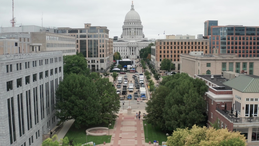 Wisconsin state capitol building in Madison, Wisconsin showing street and drone video moving up.