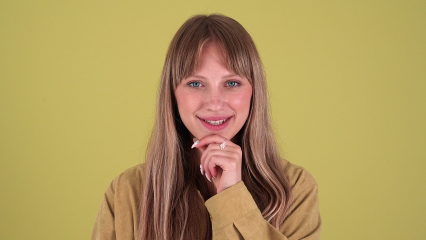 Smiling blonde woman thinking and agrees isolated over green background in studio