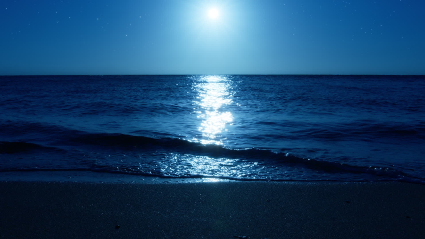 Beautiful sea at night with ripples from bluish moonlight as seen from the coast. Sandy beach washed with calm sea waves splashing on the shore with full moon above. High quality FullHD footage Royalty-Free Stock Footage #1094422691
