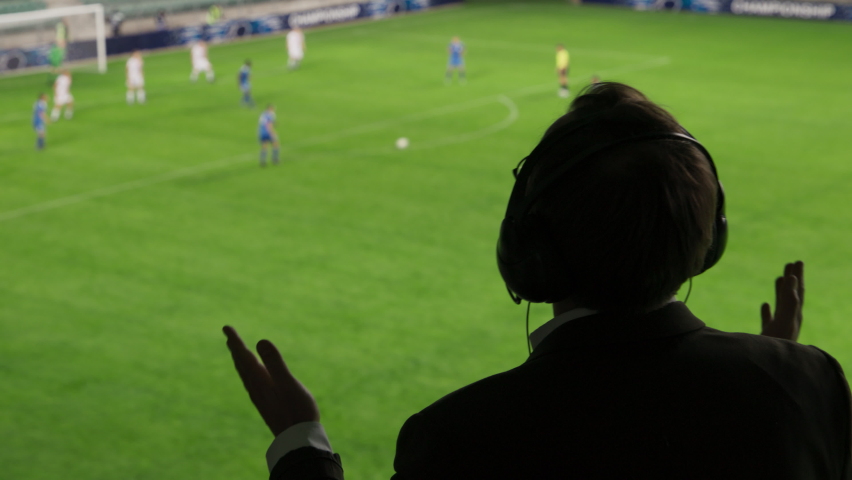 Back View Sports Commentator Analysing Soccer Match, Live Game, Celebrating Goal and Championship Victory. Silhouette of Announcer with Football Stadium Before Him Commenting on the Seasons Best Game Royalty-Free Stock Footage #1094423661