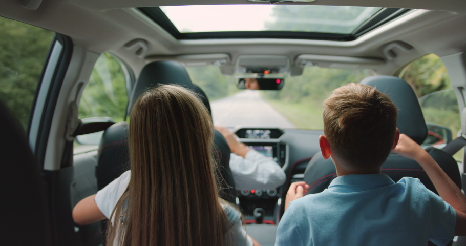 Two little boy and girl listens enjoys music and dancing while road trip. Children are playing in the car. Concept of journey. Royalty-Free Stock Footage #1094432595