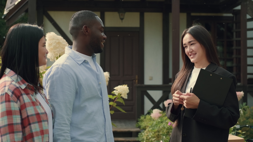 Asian female real estate agent sells house to African husband and Caucasian wife and hands over the keys.Multiracial Family,Mixed Race,Diverse People,Multiethnic Relations | Shutterstock HD Video #1094438121