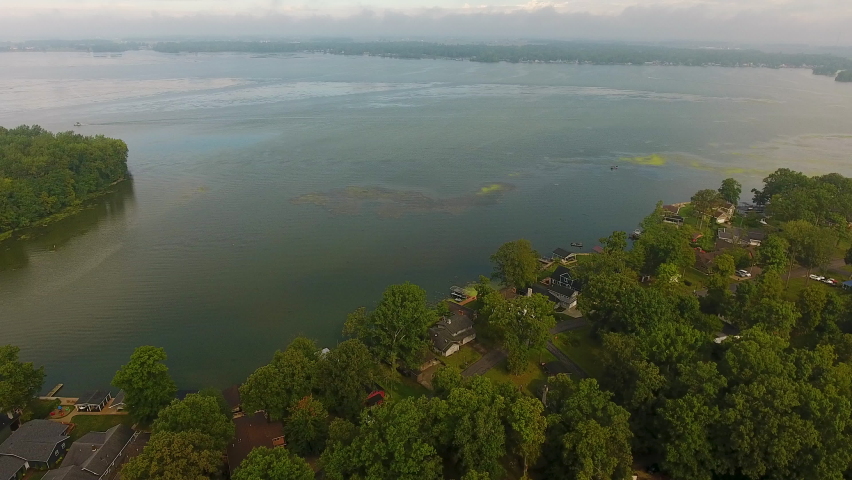 Drone shot of Indian Lake in Ohio, descending aerial shot towards the tree line around the water