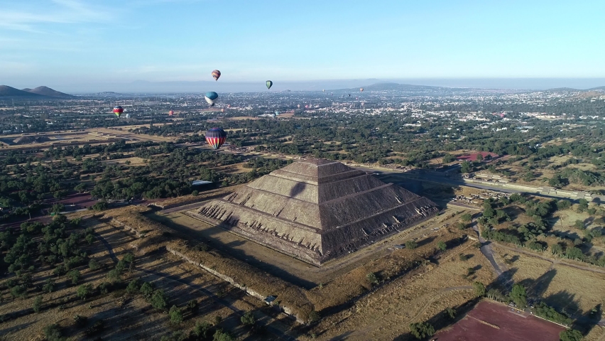 Aerial view of balloon riding around the Pyramid of the sun, in sunny Teotihuacan, Mexico - orbit, drone shot