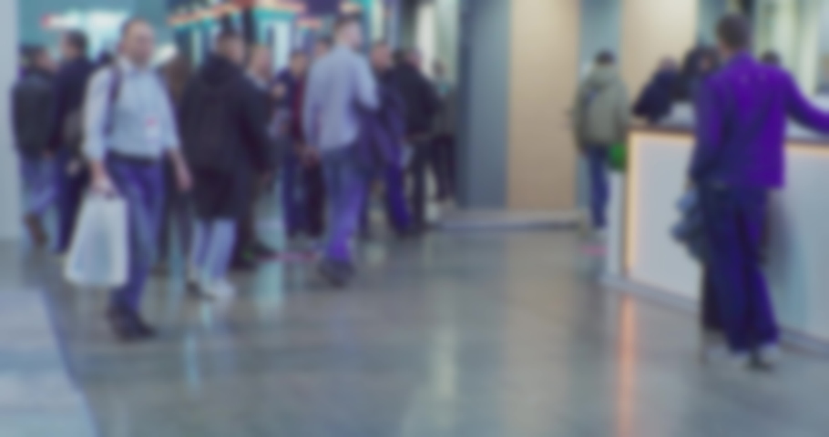 Timelapse.A crowd of unrecognizable people quickly moves in a large hall.Blurred defocused video on the topic of business.