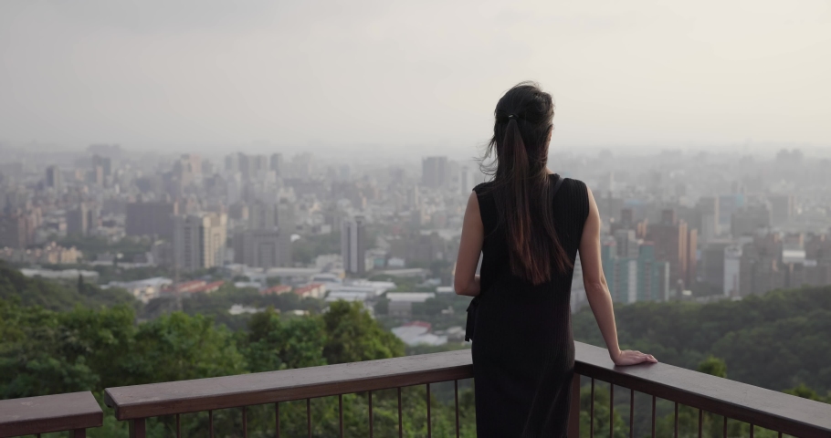 Woman look at the city view under sunset