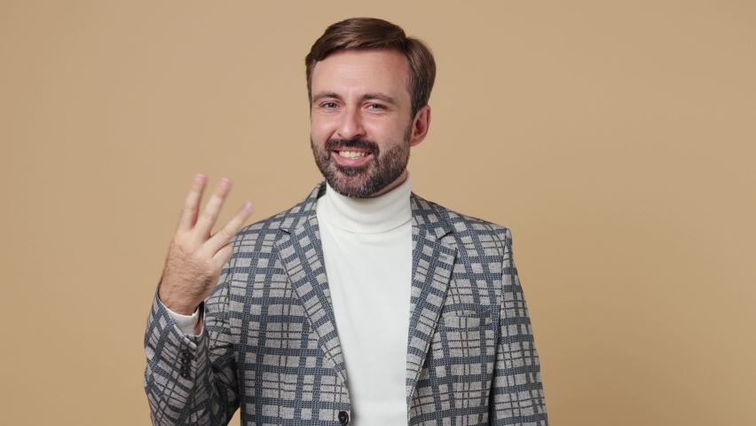 Young employee business man corporate lawyer in grey suit jacket countdown 1 2 3 one two three go celebrate win scream do winner gesture work in office isolated on plain pastel light beige background | Shutterstock HD Video #1094455327