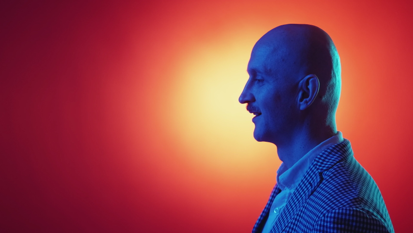 Positive communication. Happy man. Neon light portrait. Smiling profile guy in smart casual look talking on copy space red yellow background.