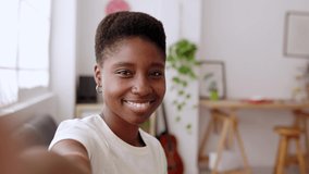 POV of happy young african woman having a video call using mobile phone app with friend while resting at home. High quality 4k footage