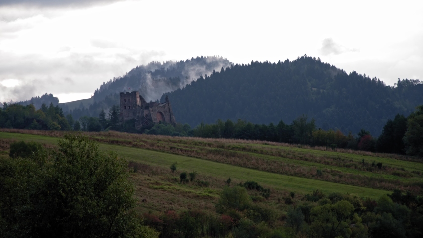 Time lapse showing moving clouds and fog, castle and sheep grazing. Czorsztyn, Poland